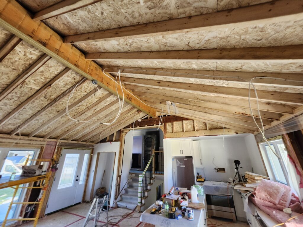 New cathedral ceiling framing around an exposed wood beam in a Burlington kitchen renovation