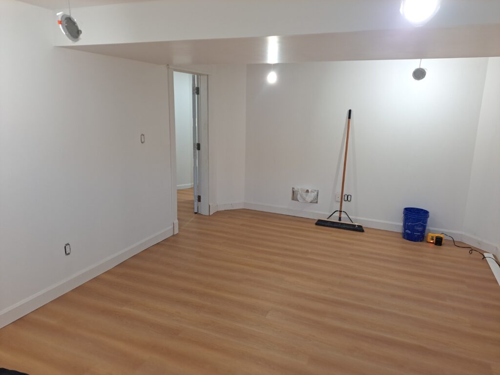 Completed baseboard around an open finished basement room in Burlington Ontario
