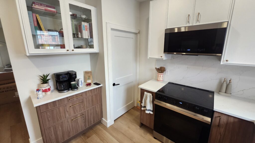 Painted interior door casing and baseboard beside completed kitchen cabinets in Hamilton